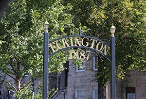 a gate with a building in the background and trees